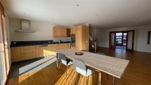 cocina grande con mesa de madera y sillas en Wunderschönes Gästehaus mit grandioser Aussicht en Gempen