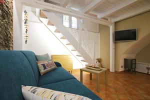 a living room with a blue couch and a staircase at Antica Cefalu' in Cefalù