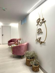 sala de estar con sofá rosa y mesa en Apartamentos Ruta da Auga, en Ribadumia