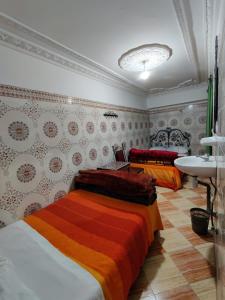マラケシュにあるHotel Medinaのベッドルーム(ベッド2台、シンク付)