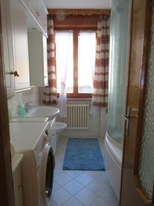 een badkamer met een wastafel, een bad en een toilet bij Stüa Valfurva in Valfurva