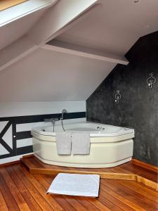 a bathroom with a bath tub in the attic at La Borzeux in Stavelot