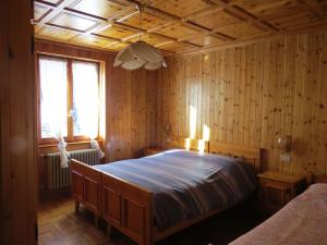 a bedroom with a large bed in a room with wooden walls at Stüa Valfurva in Valfurva