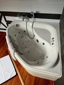 a white bath tub sitting on top of a wooden floor at La Borzeux in Stavelot +11 photos