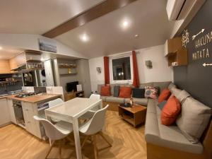 een woonkamer met een bank en een tafel bij Neuf 2022, 6-8 personnes, piscine, vacancesdenani in Saint-Julien-en-Born