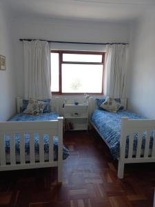 a bedroom with two beds and a window at Beach dream in Fish hoek