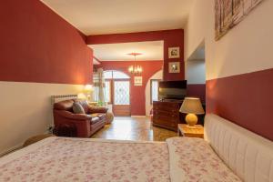 a bedroom with a bed and a couch and a television at Charm amidst Lakes & Mountains in Ramponio