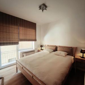 Un dormitorio con una cama grande y una ventana en Stijlvol appartement met zeezicht Nieuwpoort en Nieuwpoort
