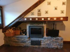 a living room with a fireplace with a tv at Acogedor apartamento de montaña con jardín y piscina - VU-HUESCA-23-182 in Benasque