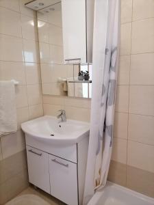 a white bathroom with a sink and a mirror at Apartmani Marijana in Lozovac