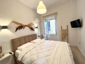 a bedroom with a white bed with a bird on the wall at Nenas Volto Apartment in Corfu