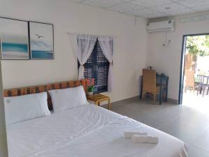1 dormitorio con cama, mesa y ventana en Homestay Miền Biển Vĩnh Hy, en Vĩnh Hy