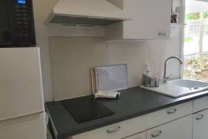uma cozinha com um lavatório e um computador portátil no balcão em TI-TI Diamant Studio Plage du Diamant 2 Pers Clim WIFI em Le Diamant