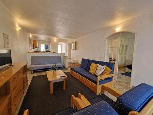 a living room with a blue couch and a tv at douceur d'algarve in Albufeira