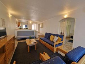 a living room with a blue couch and a tv at douceur d'algarve in Albufeira +15 photos