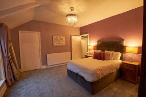 a bedroom with a large bed and a chandelier at Your Home from Home - River bank in Cox Green