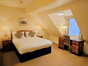 a bedroom with a large bed and a window at Orton Hall Hotel & Spa in Peterborough