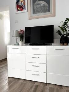 a white dresser with a television on top of it at Studio Apartman Lucija in Osijek