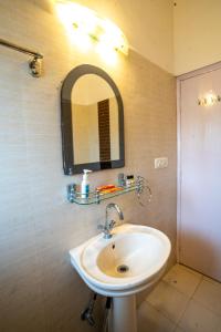 baño con lavabo y espejo en la pared en Brown Stone Villa en Bhīm Tāl