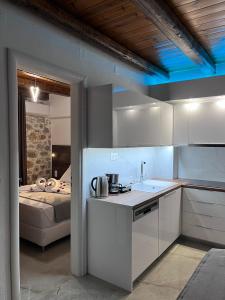 a kitchen with white cabinets and a bed in a room at Double Bee Villa with private pool in Agios Konstantinos