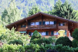 a log cabin in the mountains with trees at Chalet Rosemarie in Ringgenberg