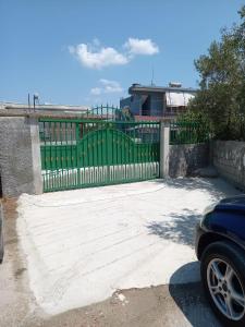 a green gate in front of a building at Vila Demo in Vlorë