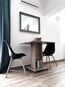 a desk and a chair in a room with a mirror at Studio Apartman Lucija in Osijek