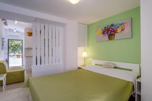 1 dormitorio con 1 cama con colcha verde en Lotta, en Nerezine
