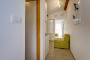 un pasillo con una silla verde en una habitación en Lotta, en Nerezine
