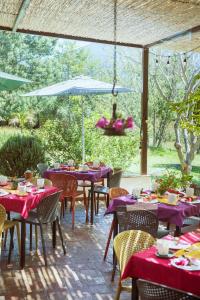 un patio con mesas, sillas y una sombrilla en PASSADHI Ayurveda & Yoga Retreat, en Villa de Leyva