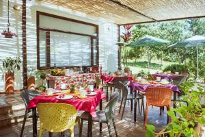 un restaurante con mesas y sillas con mantel rojo en PASSADHI Ayurveda & Yoga Retreat, en Villa de Leyva