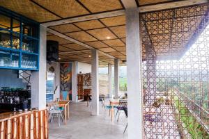 un restaurante con un patio con mesas y sillas en Gunza Bed and Breakfast by BIJAK en Jatiluwih