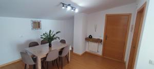 a dining room with a table and chairs and a door at Apartamentos Motilla del Azuer in Daimiel