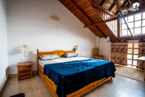 a bedroom with a large wooden bed with blue sheets at Brown Stone Villa in Bhīm Tāl