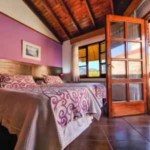 een slaapkamer met een bed en een glazen deur bij POSADA NEHUEN in Villa General Belgrano