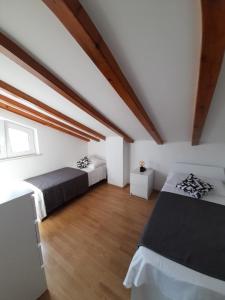 a attic bedroom with two beds and a wooden floor at Villa-kuća za odmor "RATAC" in Bol