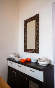 a mirror on a wall next to a counter with dishes at Brown Stone Villa in Bhīm Tāl