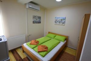 Schlafzimmer mit einem Bett mit grüner Bettwäsche in der Unterkunft LM Rooms in Banja Luka