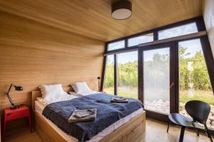 a bedroom with a bed and a large window at PortusHome Vászoly in Vászoly