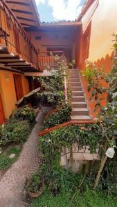 um edifício com uma escadaria com plantas e flores em Wayras Hostal em Ollantaytambo