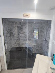 y baño con ducha y puerta de cristal. en Espectacular apartamento con spa privado, en Miami Platja