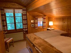 a bedroom with a bed in a wooden room at Chalet Rosemarie in Ringgenberg