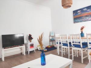 a living room with a tv and a table and chairs at Hogar acogedor en Trujillo in Trujillo