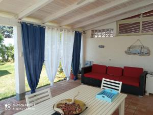 a living room with a red couch and a table at Villa Amenta in Fontane Bianche