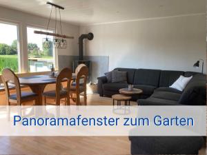 een woonkamer met een bank en een tafel bij STRANDLIEBE 100 qm Gartenwohnung (eingezäunt), 15 Gehminuten zum Strand in Neukirchen