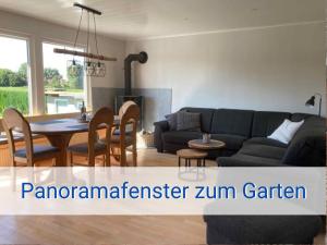 ein Wohnzimmer mit Sofa und Tisch in der Unterkunft STRANDLIEBE 100 qm Gartenwohnung (eingezäunt), 15 Gehminuten zum Strand in Neukirchen
