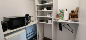 a kitchen with a microwave and a tv on a shelf at Ocalm in Longjumeau