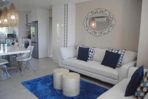 a living room with a white couch and a blue rug at 65 Key Largo in Kingsburgh