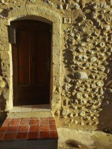Maison avec vue sur la vallée d'Asse في Saint-Julien-dʼAsse: باب لمبنى حجري بخطوات طوبية وجدار من الطوب