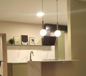 a kitchen with two pendant lights and a counter top at Butas Šiaulių centre in Šiauliai